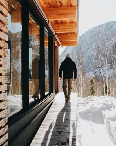 Un homme à l'extérieur d'un chalet du Parc national des Grands-Jardins en hiver.