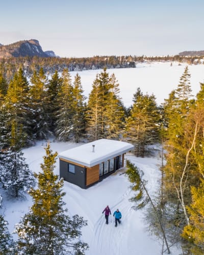 Deux personnes en raquette près d'un chalet du Parc national du Bic.