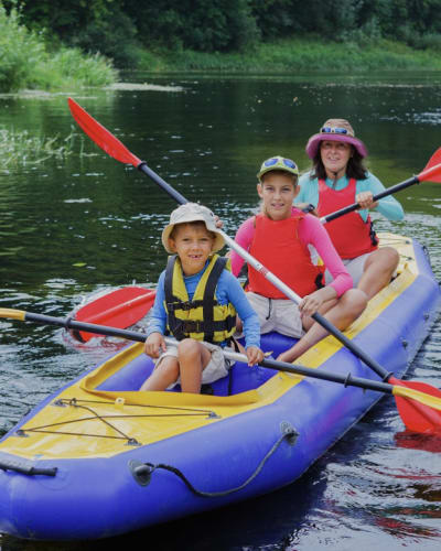 Family kayaking on an inflatable kayak on a river.