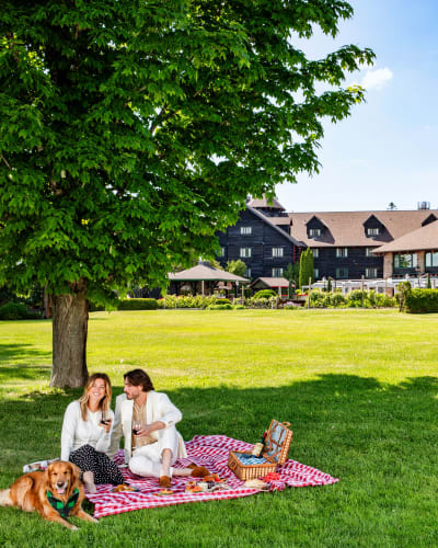 Two people sharing a picnic in a garden.