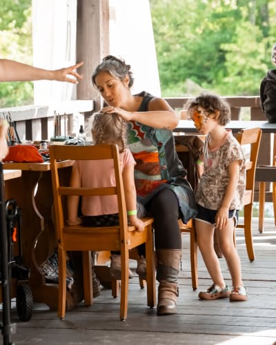 Festi-Enfant au Moulin - A woman applying face paint to a child