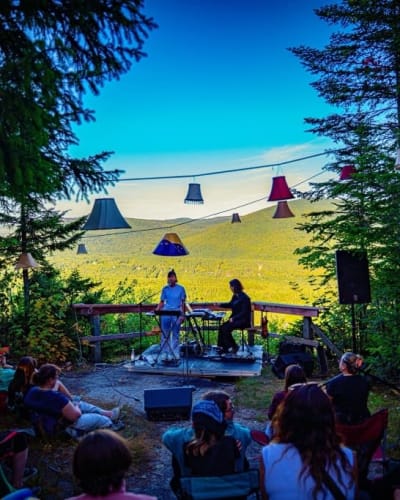 Concert au belvédère : public assis, abat-jours et vue sur la vallée
