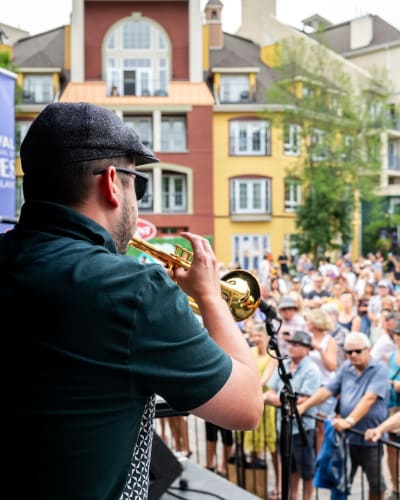 Trumpet player on stage and the crowd watching him.