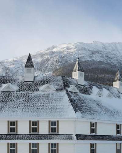 The Gîte du Mont-Albert in winter, with a mountain in the background.