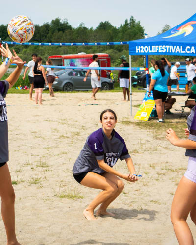 3 young women playing volleyball.