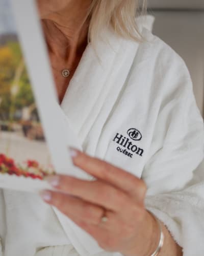 A woman wearing a Hilton bathrobe.