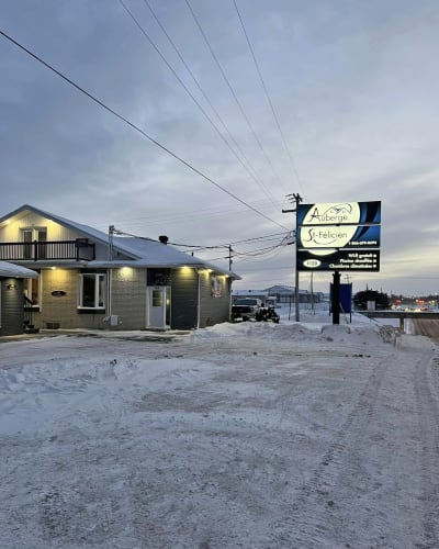 The exterior of the Hôtel Auberge St-Félicien in winter.