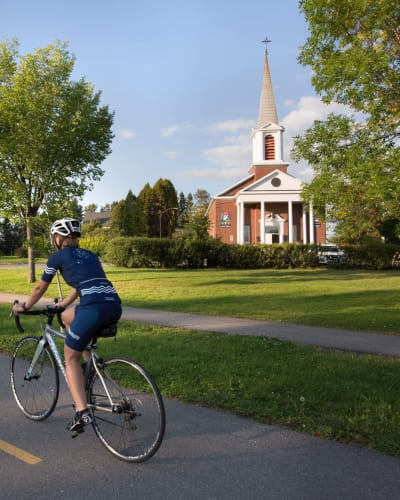Personne en vélo devant l'hôtel Le Sainte-Crème.