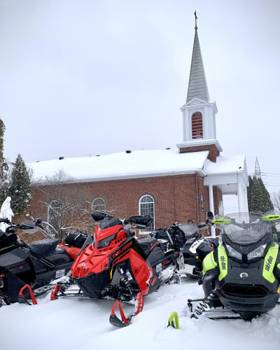 Des motoneiges à côté de l'hôtel Le Sainte-Crème.