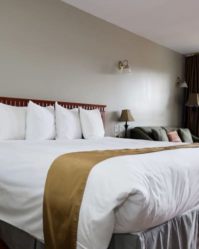 Room with king bed and sofa at Hotel & Suites Les Laurentides.