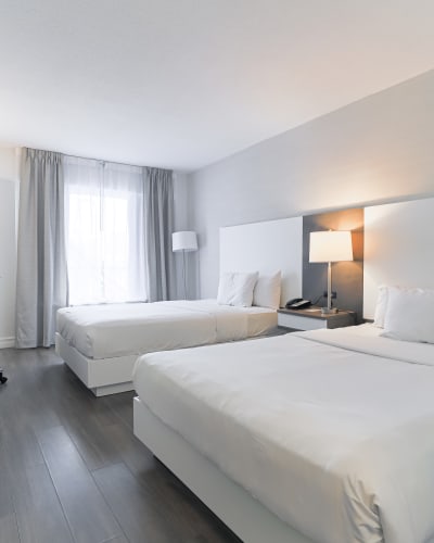 A room with two double beds at Hôtel Universel Québec.