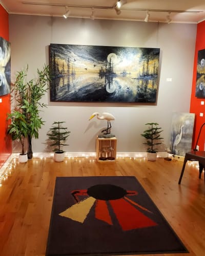 Galerie de Miss Rey displaying paintings of landscapes and birds.