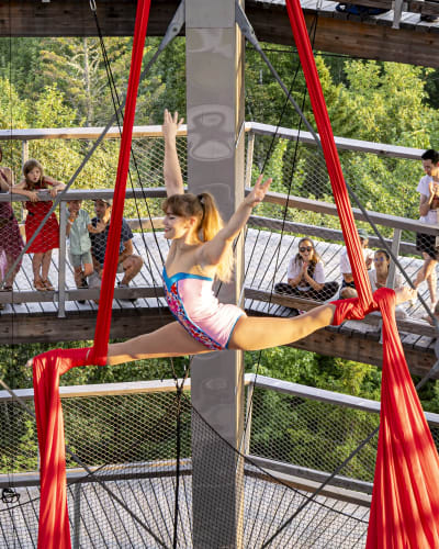 Acrobate faisant un grand écart dans les airs. 