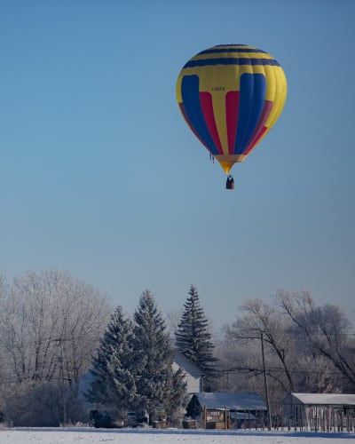 Hot air balloon flight in a winter landscape.