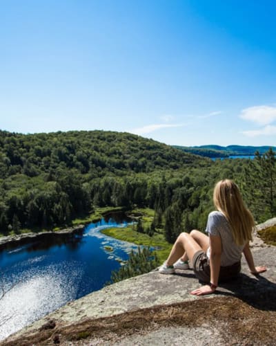A hiker looking out at the horizon from a mountaintop. 