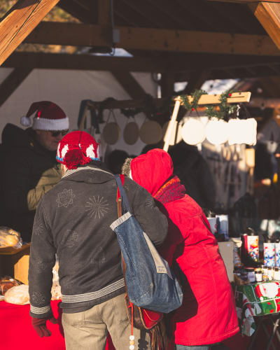 Deux personnes à un kiosque d'un Marché de Noël en Memphrémagog.