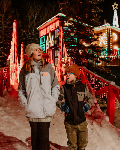 Two children in front of Maison du Père Noël (Santa's House).