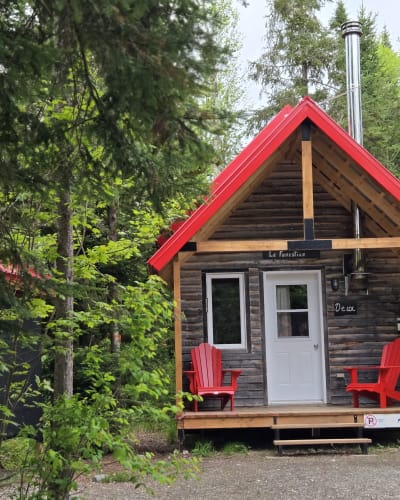 Micro-Chalets des Appalaches - Small cabin with two red chairs on the deck