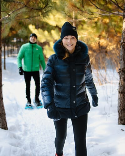 Couple playing snowshoeing in winter at Moulin des Pionniers.