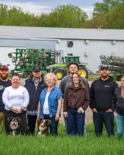 Famille de la Ferme Agrikel devant la ferme et tracteurs.