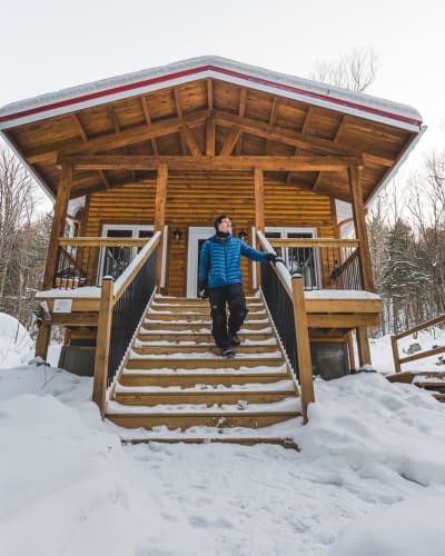 Homme devant un chalet.