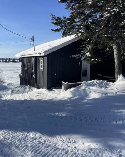 Pourvoirie Fern - Chalet noir en hiver