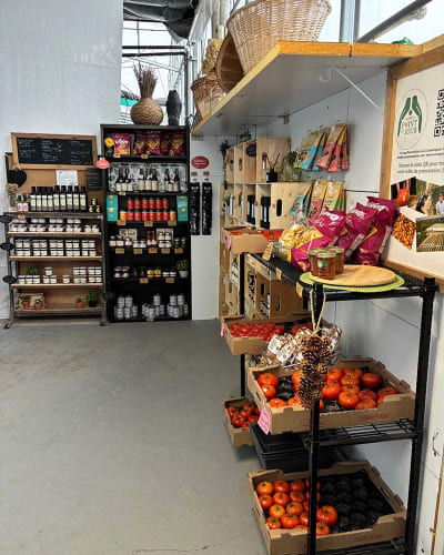 Indoor kiosk selling produce and tomatoes.