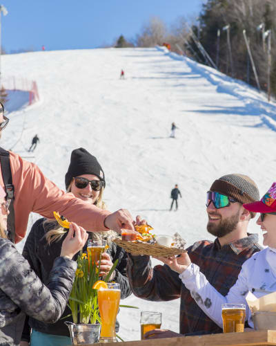 Friends are eating at the bottom of the Sommet Saint-Sauveur ski mountain.