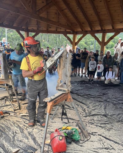 Symposium de sculpture à la tronçonneuse - A man creates a wood sculpture with a chainsaw