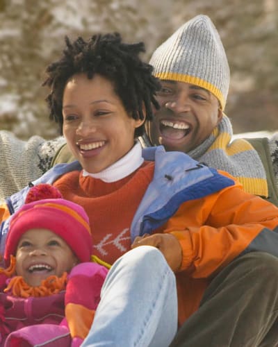 A happy family sliding down the snow.