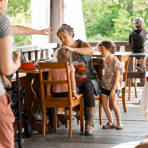 Festi-Enfant au Moulin - A woman applying face paint to a child