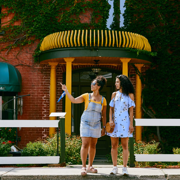 The artists and artisans of Montebello - Two individuals are standing on a sidewalk, looking in the same direction.