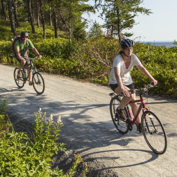 Parc national de la Pointe-Taillon - A man and a woman cycling in nature