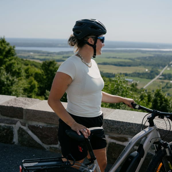 A woman on a bicycle at the Champlain lookout point in the summer.