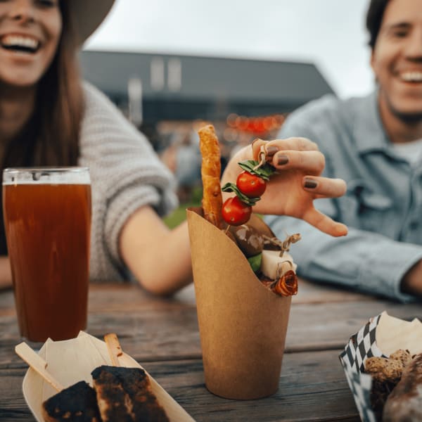 Couple à table avec bière et repas.