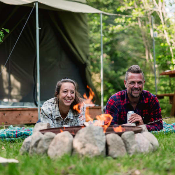 Couple devant un prêt-à-camper au Camping Sainte-Agathe-des-Monts au Parc régional Sainte-Agathe-des-Monts.