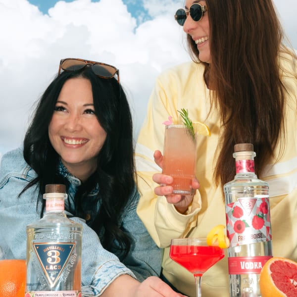 Two woman drinking a cocktail.