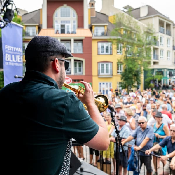Trumpet player on stage and the crowd watching him.