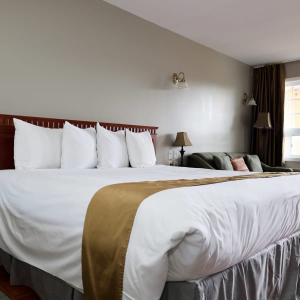 Chambre avec lit king et sofa à l'Hôtel & Suites Les Laurentides.