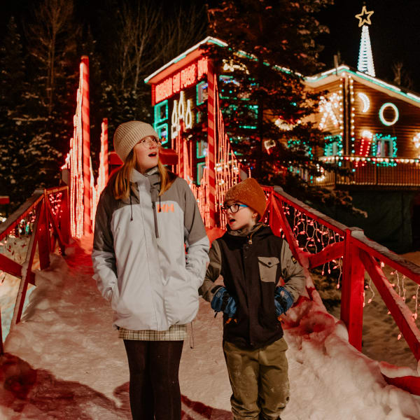 Two children in front of Maison du Père Noël (Santa's House).