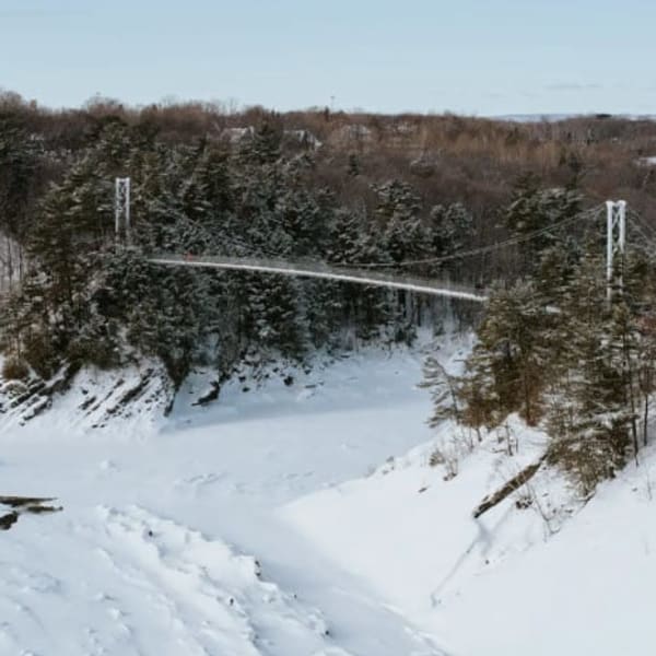 Aerial view of the footbridge over the river in winter.