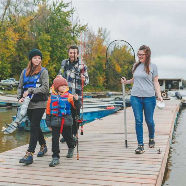 Family on a dock, setting off to go fishing.
