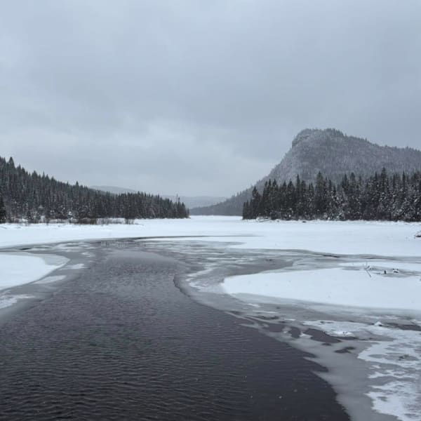 Winter landscape with river and mountains.