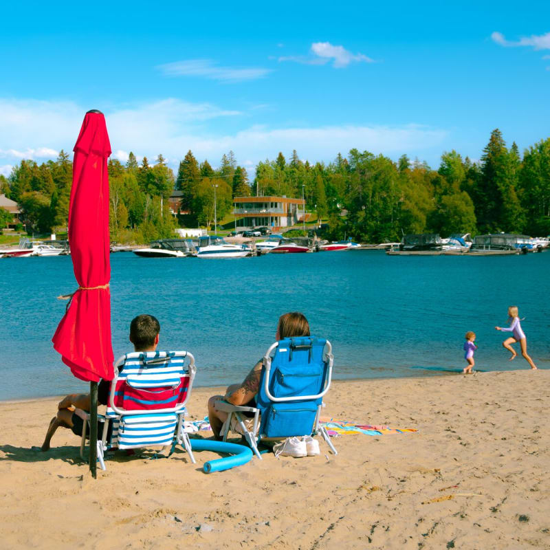 Centre de villégiature Dam-en-Terre - Deux personnes assises sur des chaises à la plage