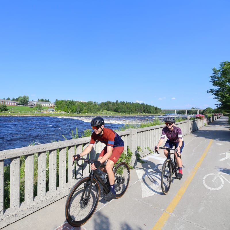 Two cyclists on a waterfront bike path.