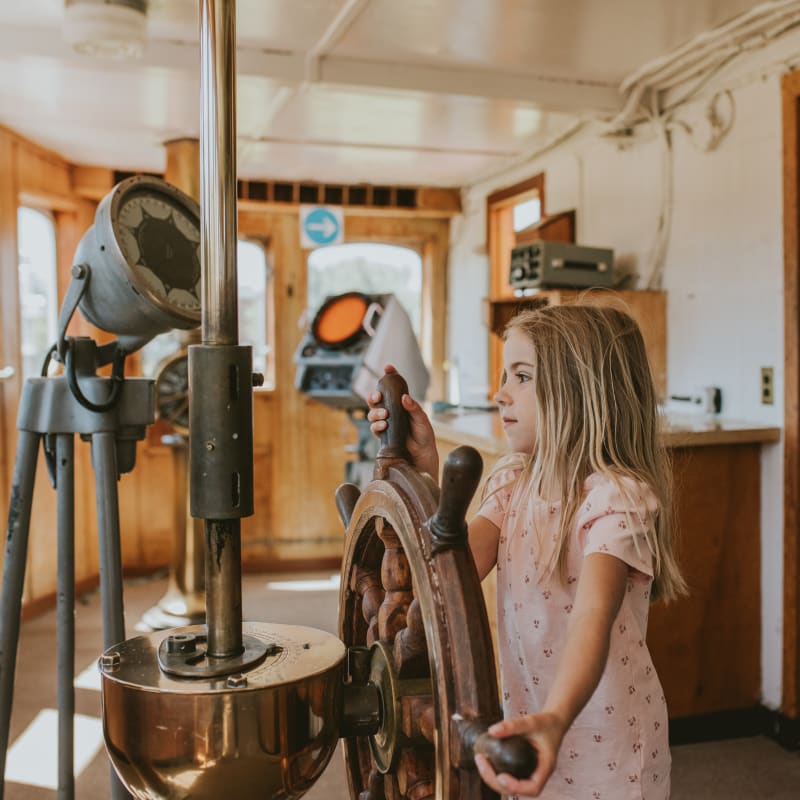 Girl at the helm of a ship's bridge