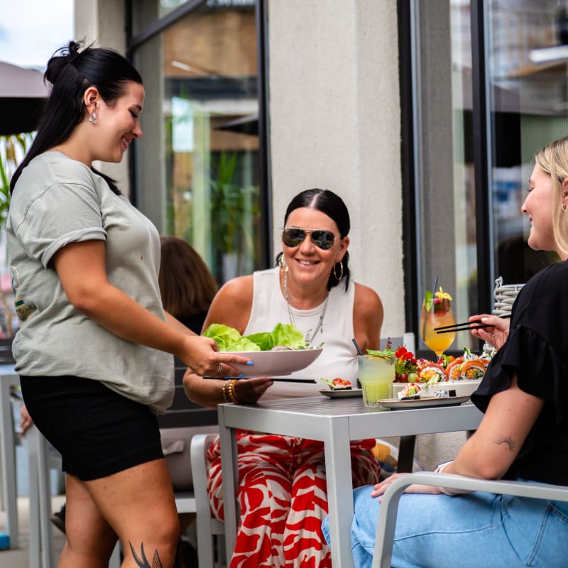 Destination Salaberry-de-Valleyfield - A waitress brings a dish to a table where two women are seated.