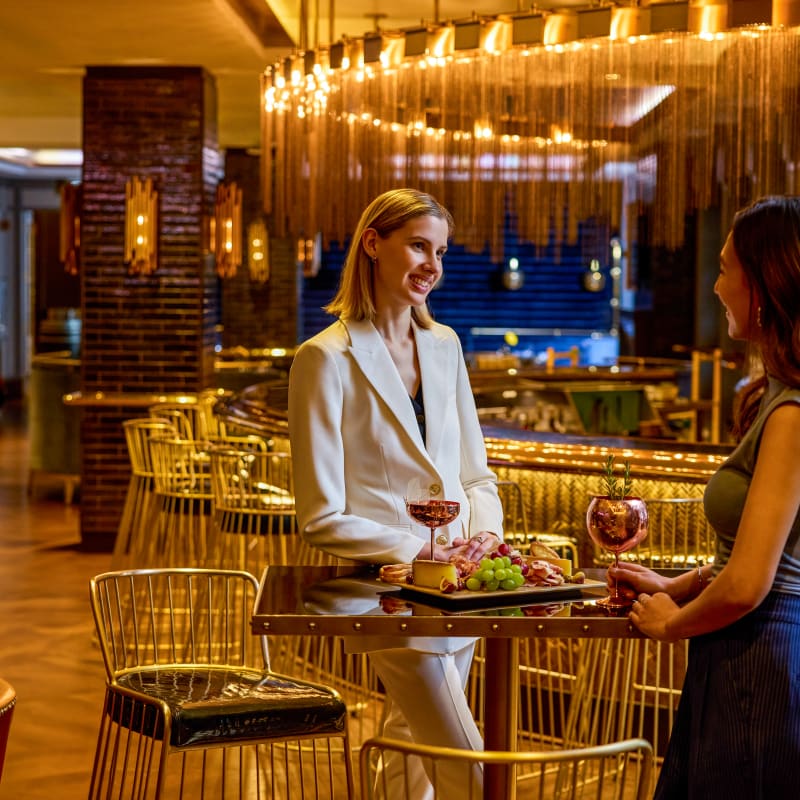 Two women at a high table at Bistro Le Sam.