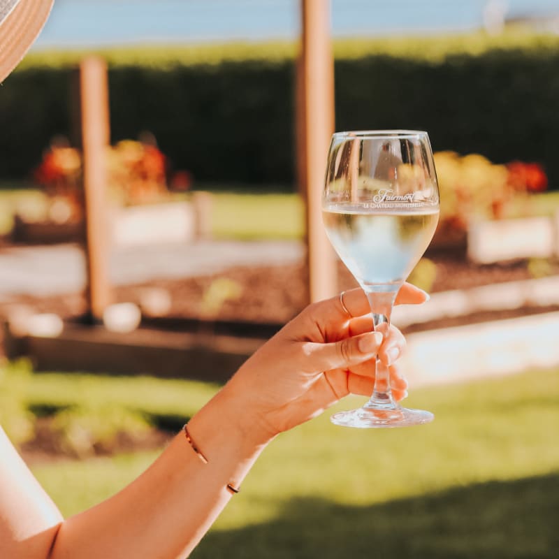 Close-up of a glass of white wine held by a woman