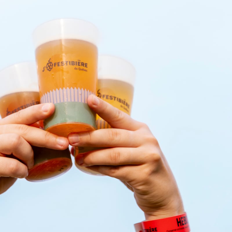 Le Festibière de Québec - Two hands hold three glasses filled with a liquid